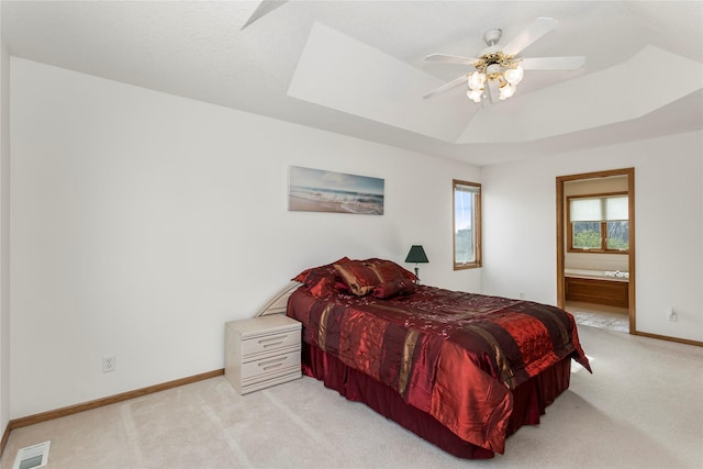 9040 Telford Cir, Johnston, IA 50131 - bedroom featuring light carpet, baseboards, ensuite bathroom, a raised ceiling, and a ceiling fan
