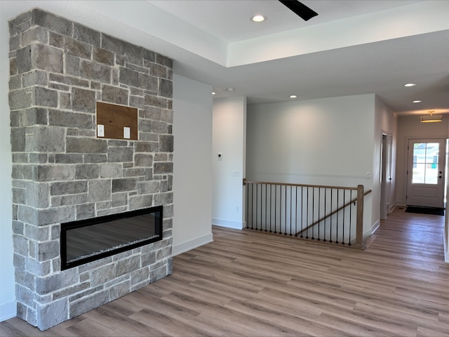 1112 2nd St NE, Altoona, IA 50009 - unfurnished living room with wood finished floors, baseboards, recessed lighting, and a stone fireplace
