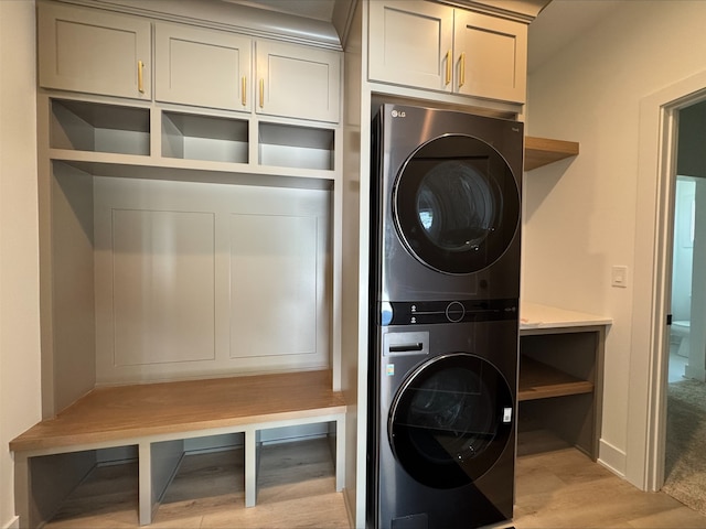 1112 2nd St NE, Altoona, IA 50009 - clothes washing area with stacked washer / drying machine, light wood-style floors, and cabinet space