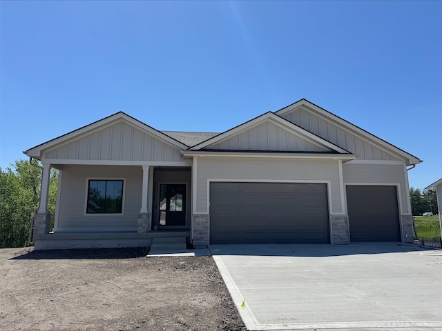 1112 2nd St NE, Altoona, IA 50009 - craftsman-style house featuring a garage, concrete driveway, a porch, and stone siding