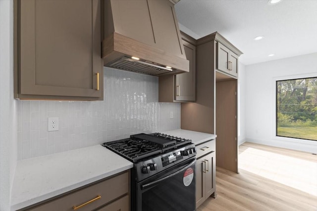 1112 2nd St NE, Altoona, IA 50009 - kitchen featuring custom range hood, black range with gas cooktop, light wood-type flooring, decorative backsplash, and recessed lighting
