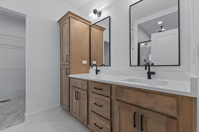 1112 2nd St NE, Altoona, IA 50009 - full bathroom with double vanity, a walk in closet, and baseboards