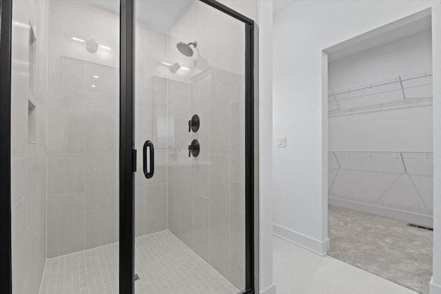1112 2nd St NE, Altoona, IA 50009 - bathroom featuring a shower stall, a spacious closet, and baseboards