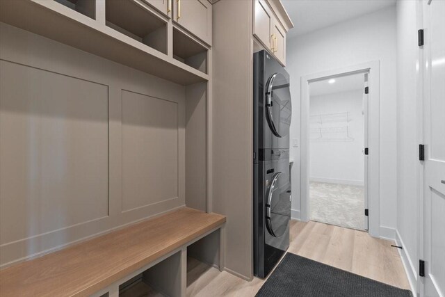 1112 2nd St NE, Altoona, IA 50009 - mudroom featuring stacked washer / dryer, light wood-style flooring, and baseboards