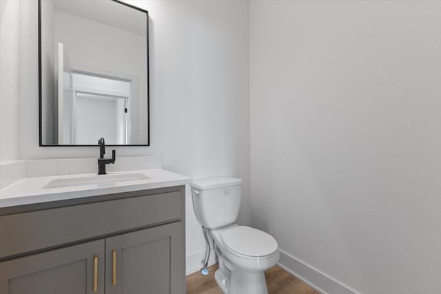 1112 2nd St NE, Altoona, IA 50009 - bathroom featuring toilet, baseboards, vanity, and wood finished floors