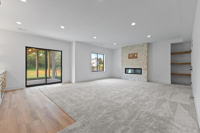 1112 2nd St NE, Altoona, IA 50009 - unfurnished living room with healthy amount of natural light, recessed lighting, baseboards, wood finished floors, and a fireplace