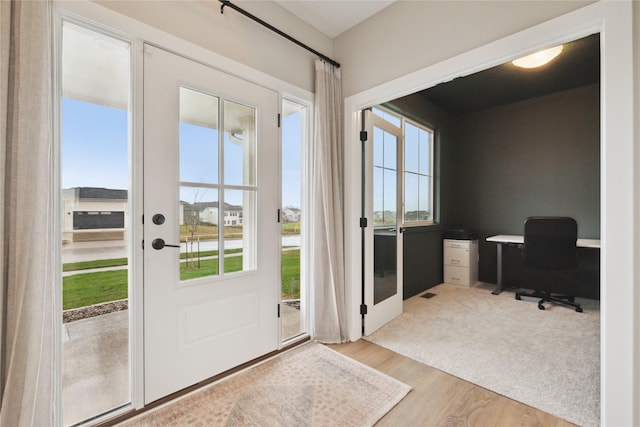 70 NW Hidden Knl, Waukee, IA 50263 - doorway to outside with wood finished floors, plenty of natural light, and an office area