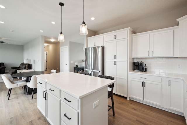 70 NW Hidden Knl, Waukee, IA 50263 - kitchen with freestanding refrigerator, light wood-style floors, a center island, recessed lighting, and backsplash