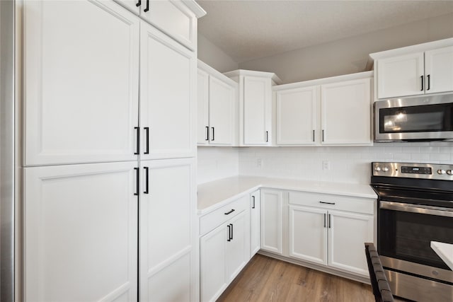 70 NW Hidden Knl, Waukee, IA 50263 - kitchen with stainless steel appliances, light countertops, white cabinets, and tasteful backsplash