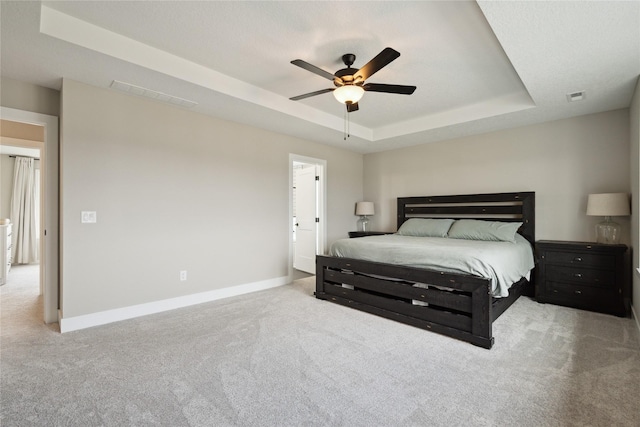 70 NW Hidden Knl, Waukee, IA 50263 - carpeted bedroom with a tray ceiling, baseboards, and a ceiling fan
