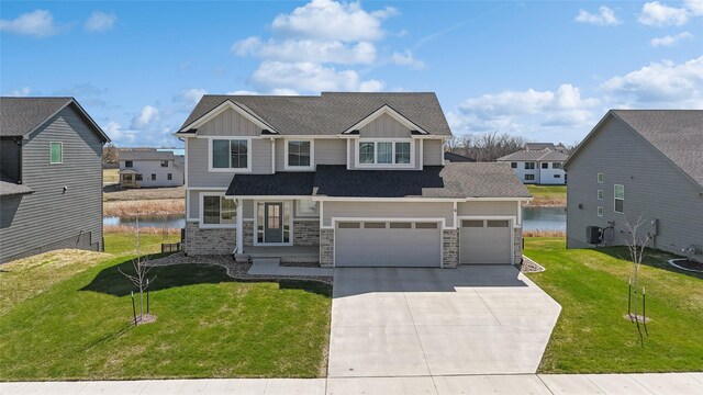 70 NW Hidden Knl, Waukee, IA 50263 - craftsman inspired home with board and batten siding, driveway, stone siding, a front yard, and a water view