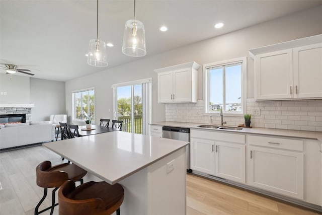 1715 Willow Ct, Norwalk, IA 50211 - kitchen with tasteful backsplash, a sink, open floor plan, dishwasher, and light countertops