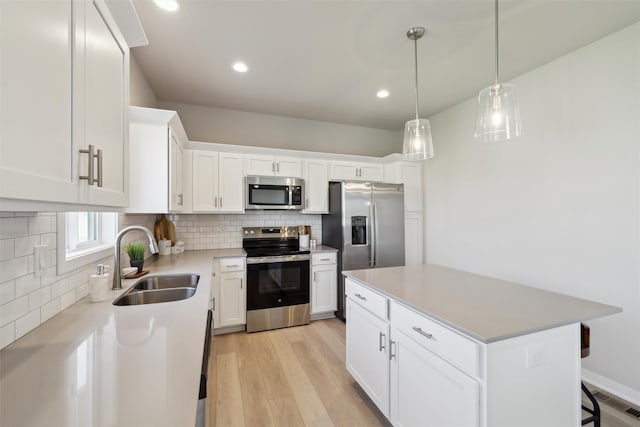 1715 Willow Ct, Norwalk, IA 50211 - kitchen featuring light wood-style flooring, decorative backsplash, stainless steel appliances, and a sink