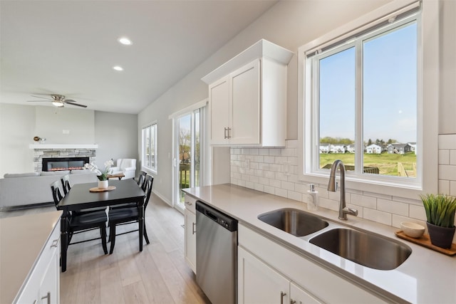 1715 Willow Ct, Norwalk, IA 50211 - kitchen featuring a ceiling fan, a sink, dishwasher, light countertops, and backsplash