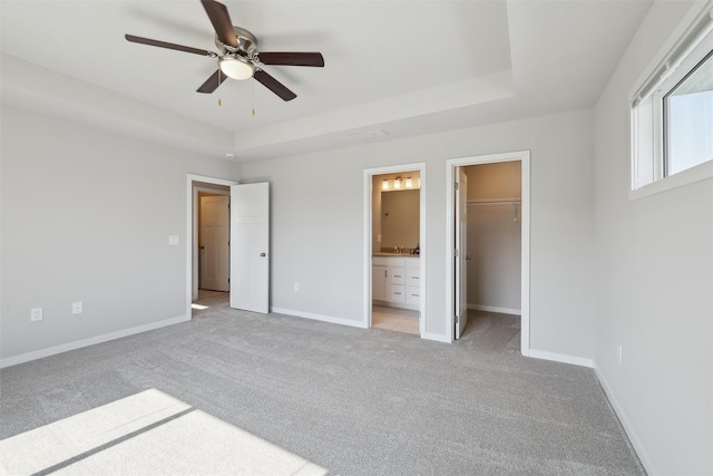1715 Willow Ct, Norwalk, IA 50211 - unfurnished bedroom with a spacious closet, ensuite bath, a raised ceiling, light colored carpet, and baseboards