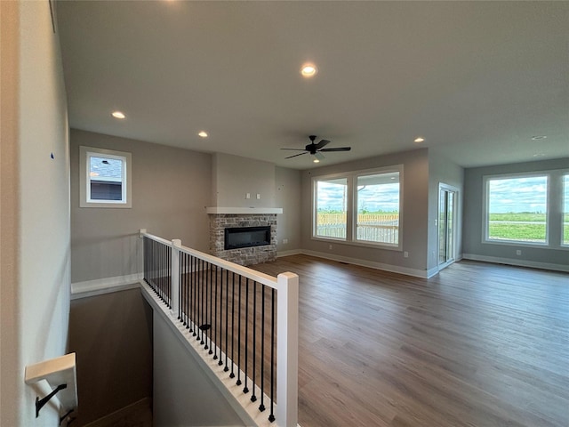 1910 Silver Maple Dr, Norwalk, IA 50211 - unfurnished living room featuring wood finished floors, healthy amount of natural light, recessed lighting, a fireplace, and a ceiling fan