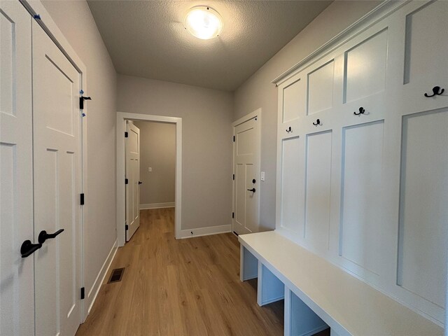 1910 Silver Maple Dr, Norwalk, IA 50211 - mudroom with light wood finished floors, baseboards, and a textured ceiling