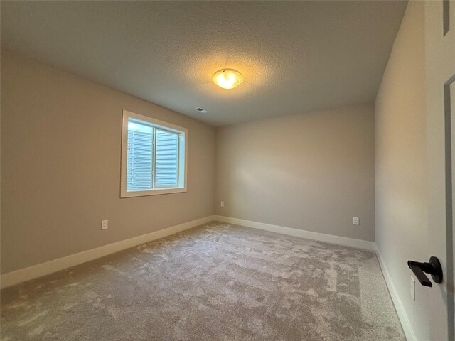 1910 Silver Maple Dr, Norwalk, IA 50211 - spare room featuring carpet flooring, a textured ceiling, and baseboards