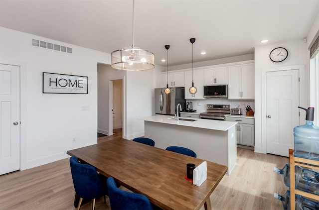 4125 NE 6th St, Ankeny, IA 50021 - kitchen featuring visible vents, a sink, a chandelier, stainless steel appliances, and light wood-style flooring