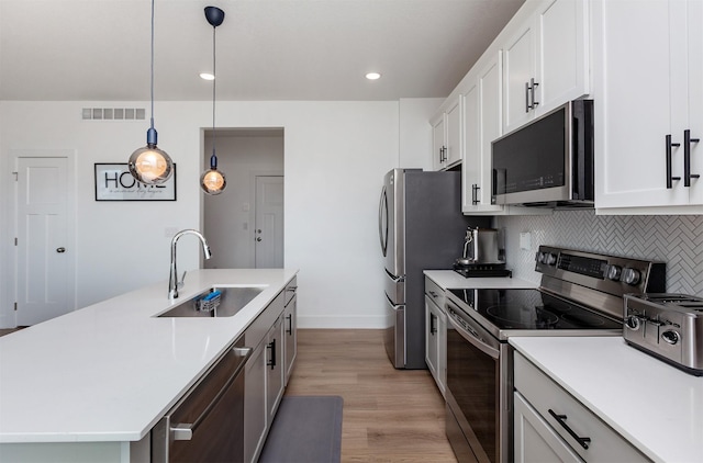 4125 NE 6th St, Ankeny, IA 50021 - kitchen with visible vents, a sink, light countertops, appliances with stainless steel finishes, and an island with sink