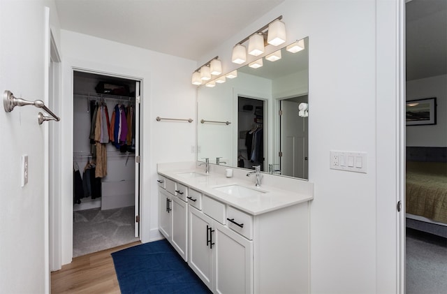 4125 NE 6th St, Ankeny, IA 50021 - ensuite bathroom with a sink, double vanity, connected bathroom, and wood finished floors
