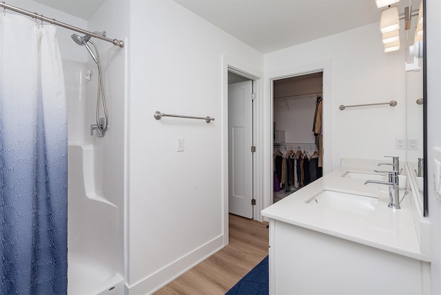 4125 NE 6th St, Ankeny, IA 50021 - bathroom featuring a walk in closet, a stall shower, and wood finished floors