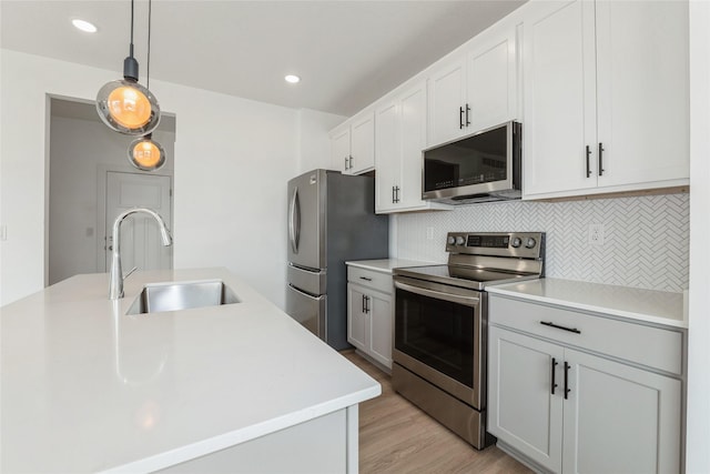 4125 NE 6th St, Ankeny, IA 50021 - kitchen featuring appliances with stainless steel finishes, a sink, light countertops, decorative backsplash, and recessed lighting