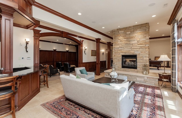 7580 NW 100th St, Johnston, IA 50131 - living area with decorative columns, ornamental molding, a stone fireplace, wainscoting, and recessed lighting
