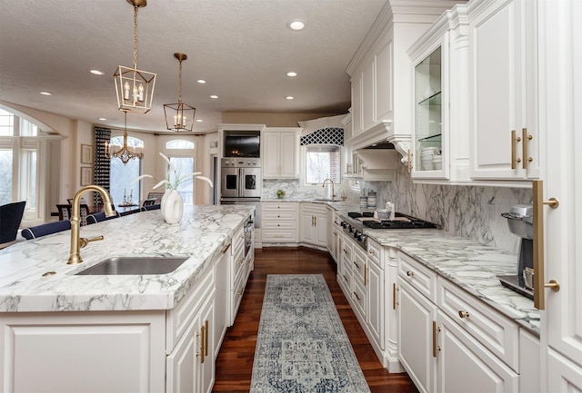 7580 NW 100th St, Johnston, IA 50131 - kitchen with appliances with stainless steel finishes, a spacious island, white cabinetry, recessed lighting, and glass insert cabinets