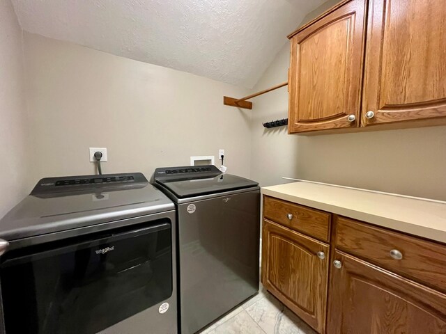 2501 Ridgewood Dr, West Des Moines, IA 50265 - laundry room featuring cabinet space, a textured ceiling, washing machine and clothes dryer, and marble finish floor