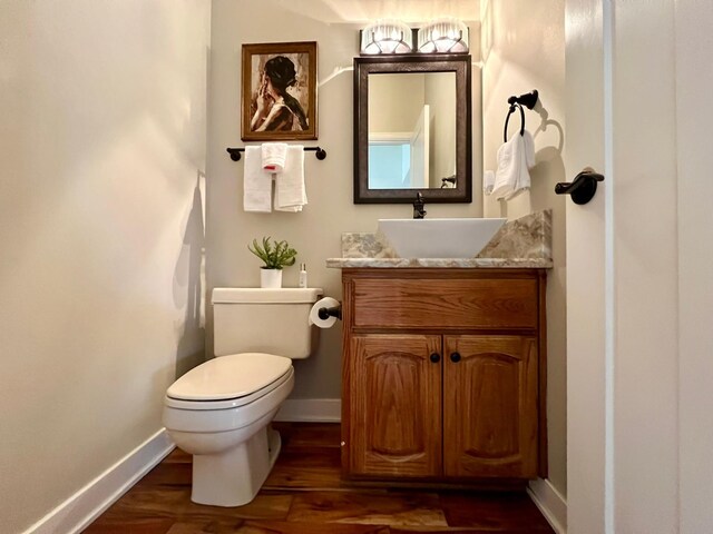 2501 Ridgewood Dr, West Des Moines, IA 50265 - bathroom with baseboards, toilet, vanity, and wood finished floors