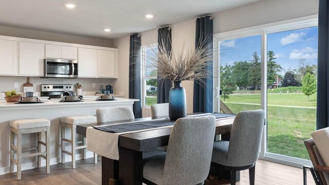 dining room with light wood finished floors and recessed lighting