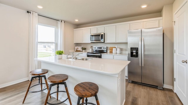1048 34th St SE, Altoona, IA 50009 - kitchen featuring light wood-type flooring, appliances with stainless steel finishes, a sink, and a breakfast bar