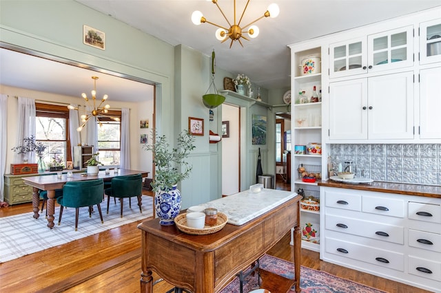 kitchen featuring open shelves, white cabinets, a chandelier, dark wood-style flooring, and backsplash