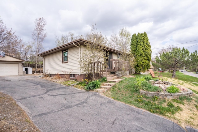 view of front of home featuring aphalt driveway, an outbuilding, and a detached garage