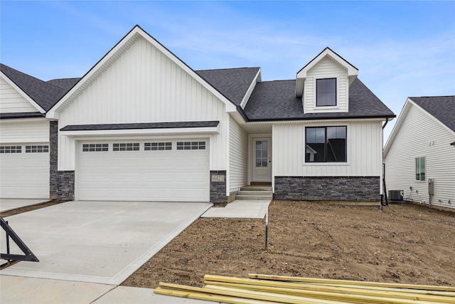 4421 NW Olivia Ln, Ankeny, IA 50023 - view of front of house featuring an attached garage, stone siding, driveway, and roof with shingles