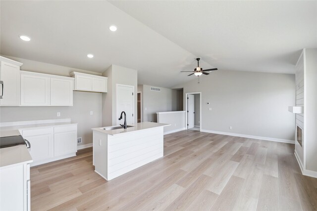 4421 NW Olivia Ln, Ankeny, IA 50023 - kitchen featuring ceiling fan, a center island with sink, white cabinetry, lofted ceiling, and a sink
