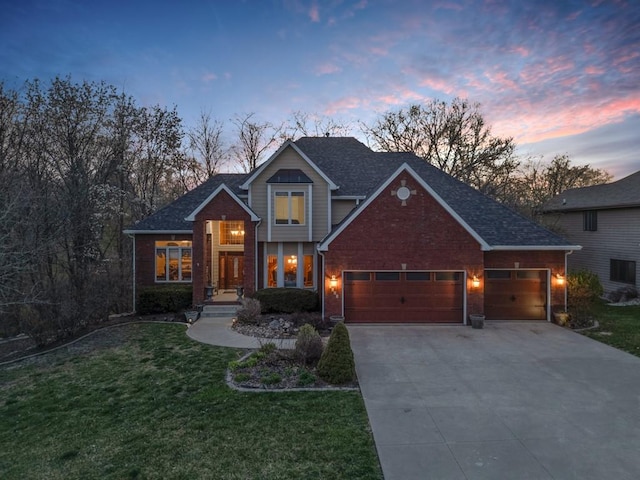 traditional home with brick siding, an attached garage, driveway, and a lawn