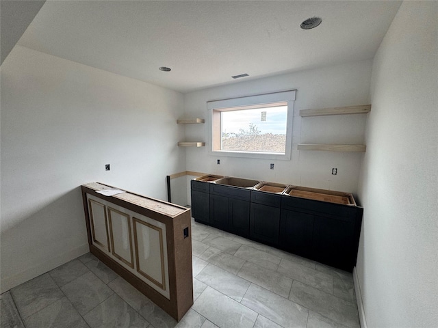 850 NW Frescott Cir, Waukee, IA 50263 - kitchen with open shelves, dark cabinetry, and light marble finish flooring