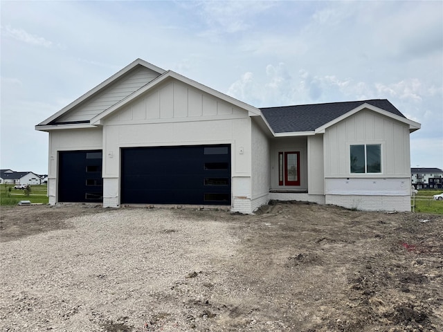 850 NW Frescott Cir, Waukee, IA 50263 - view of front of property with an attached garage, board and batten siding, roof with shingles, and driveway
