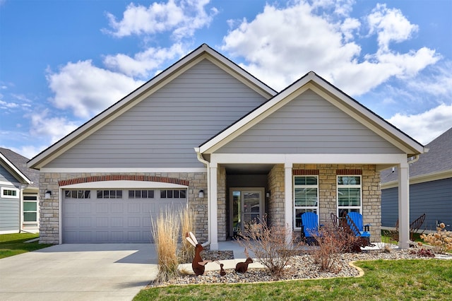 craftsman-style home with a porch, stone siding, a garage, and concrete driveway