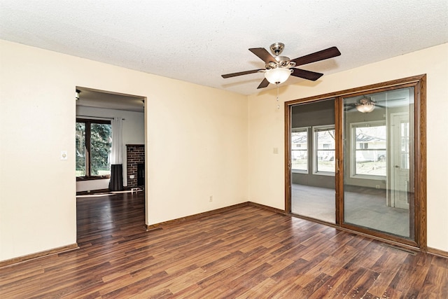 empty room featuring wood finished floors, a textured ceiling, baseboards, and ceiling fan