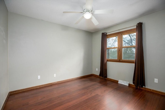 spare room featuring visible vents, baseboards, a ceiling fan, and wood finished floors