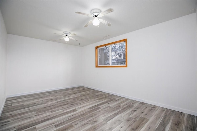unfurnished room featuring light wood-style flooring, baseboards, and a ceiling fan