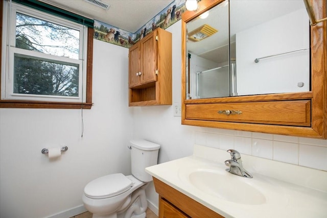 full bath with a shower with door, vanity, baseboards, and toilet