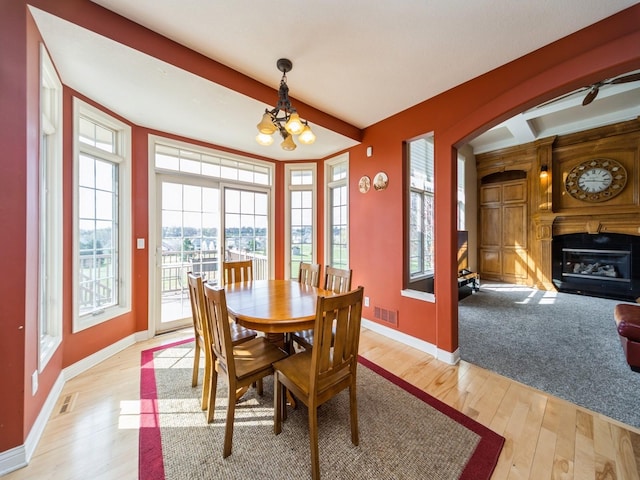 2705 147th St, Urbandale, IA 50323 - dining area featuring visible vents, a glass covered fireplace, baseboards, and light wood-style floors