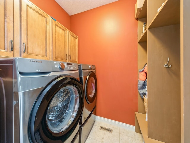 2705 147th St, Urbandale, IA 50323 - clothes washing area with a textured ceiling, baseboards, visible vents, independent washer and dryer, and cabinet space