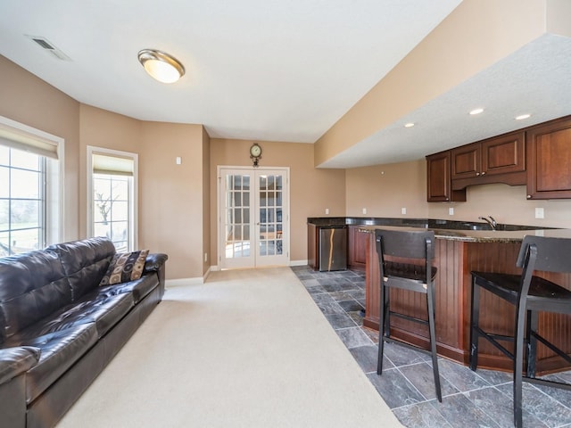 2705 147th St, Urbandale, IA 50323 - kitchen featuring open floor plan, french doors, a kitchen bar, baseboards, and visible vents