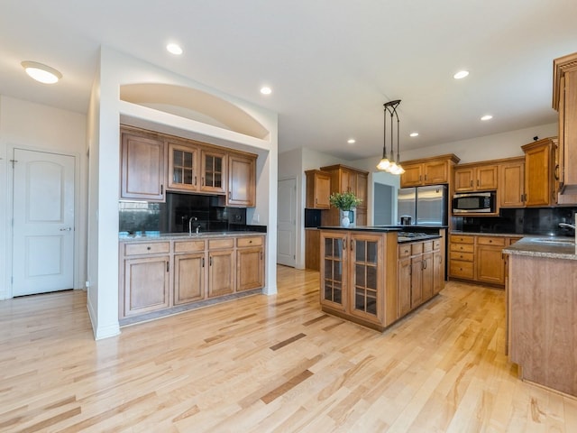 2705 147th St, Urbandale, IA 50323 - kitchen with appliances with stainless steel finishes, brown cabinetry, tasteful backsplash, light wood finished floors, and recessed lighting