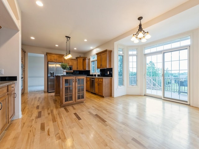 2705 147th St, Urbandale, IA 50323 - kitchen with stainless steel appliances, brown cabinets, light wood-type flooring, pendant lighting, and recessed lighting